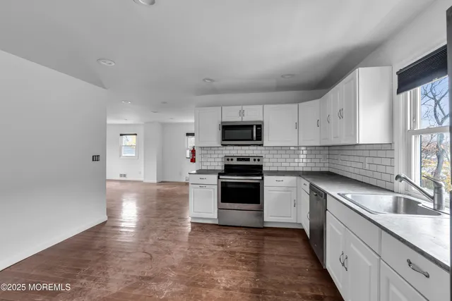 a kitchen with stainless steel appliances granite countertop a sink and cabinets