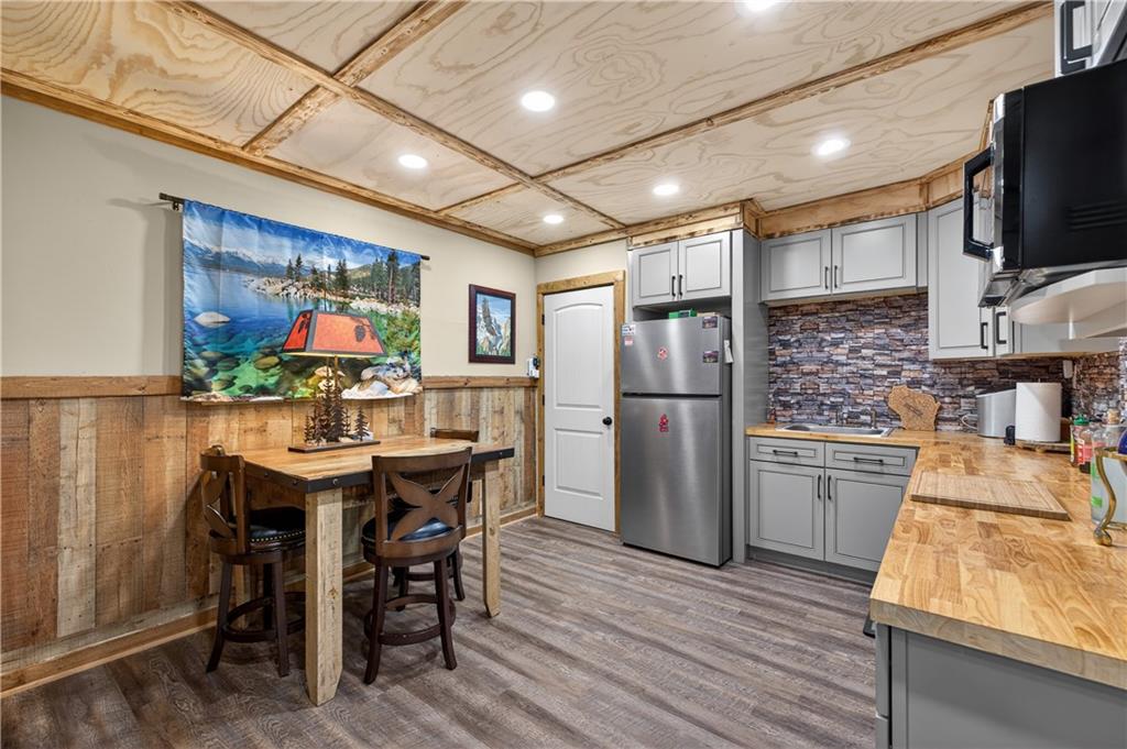 905 Old Forge Lane Jefferson, GA 30549 - Photo 44 of 69 a kitchen with stainless steel appliances granite countertop a refrigerator a stove a sink dishwasher a dining table and chairs with wooden floor