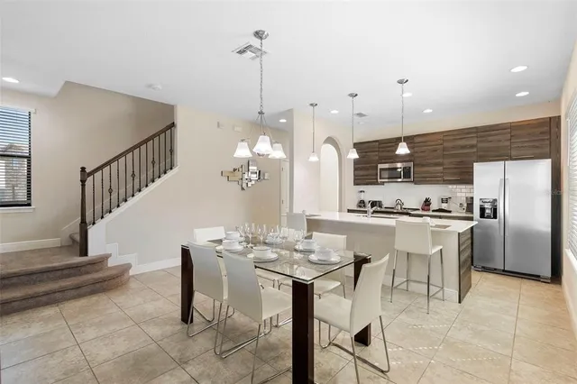 a living room with furniture and a dining table with kitchen view