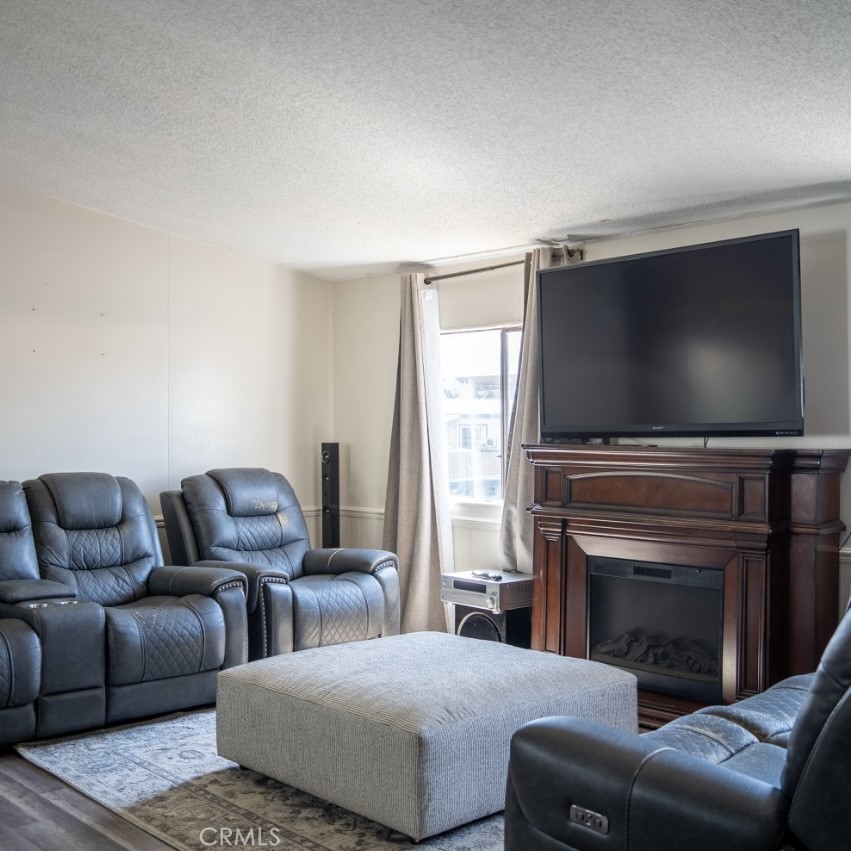 7717 Church Avenue, Unit 54 Highland, CA 92346 - Photo 3 of 13 a living room with furniture and a flat screen tv