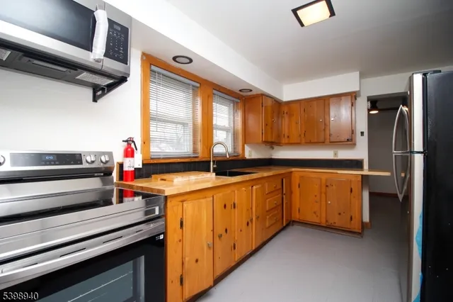 a kitchen with granite countertop stainless steel appliances and wooden cabinets