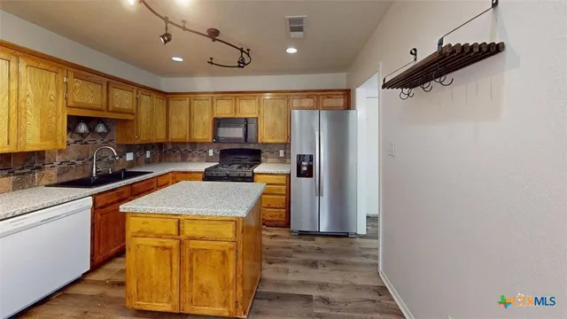a kitchen with a sink appliances cabinets and a counter top space