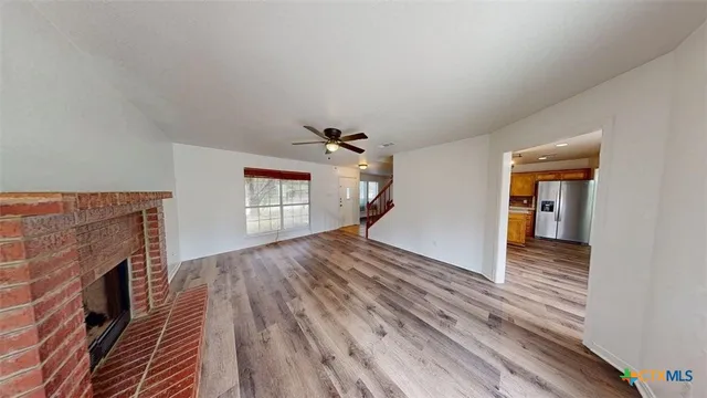 a view of a livingroom with wooden floor and a ceiling fan