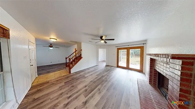 a view of a livingroom with wooden floor and a ceiling fan
