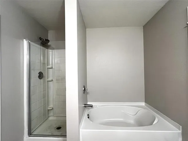 a white bath tub sitting next to a shower