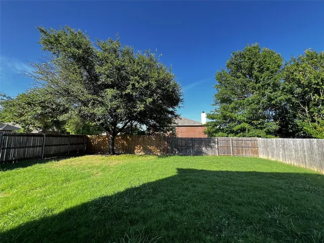 a view of green field with tree in the background