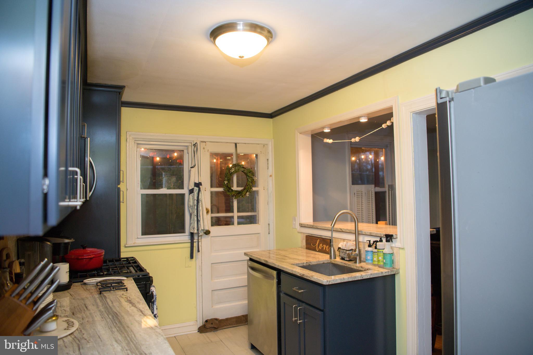 8637 Oak Road Baltimore, MD 21234 - Photo 5 of 18 a kitchen with a granite countertop sink a stove and a refrigerator