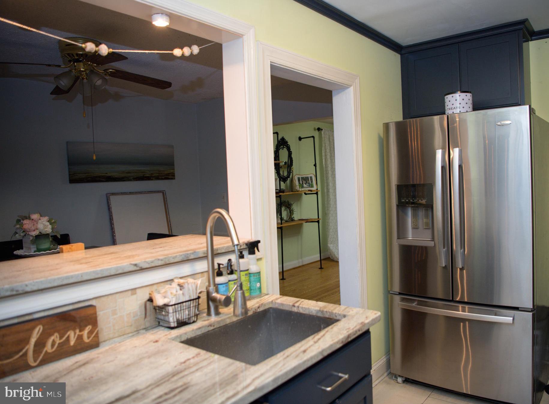8637 Oak Road Baltimore, MD 21234 - Photo 6 of 18 a kitchen with stainless steel appliances kitchen island granite countertop a refrigerator a stove and a sink with wooden floor