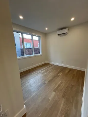 an empty room with a wooden floor and a window