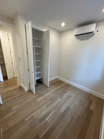 an empty room with wooden floor and stairs