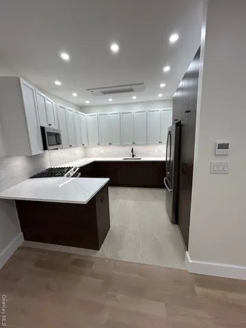 a kitchen with a sink a refrigerator and cabinets