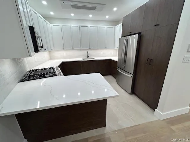 a large kitchen with a table chairs refrigerator and a sink