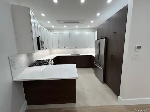 a kitchen with a sink a refrigerator and cabinets