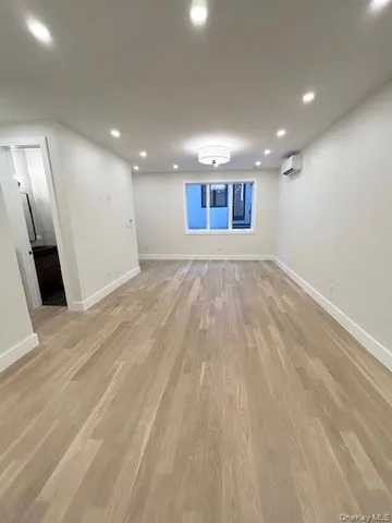 an empty room with wooden floor and entrance