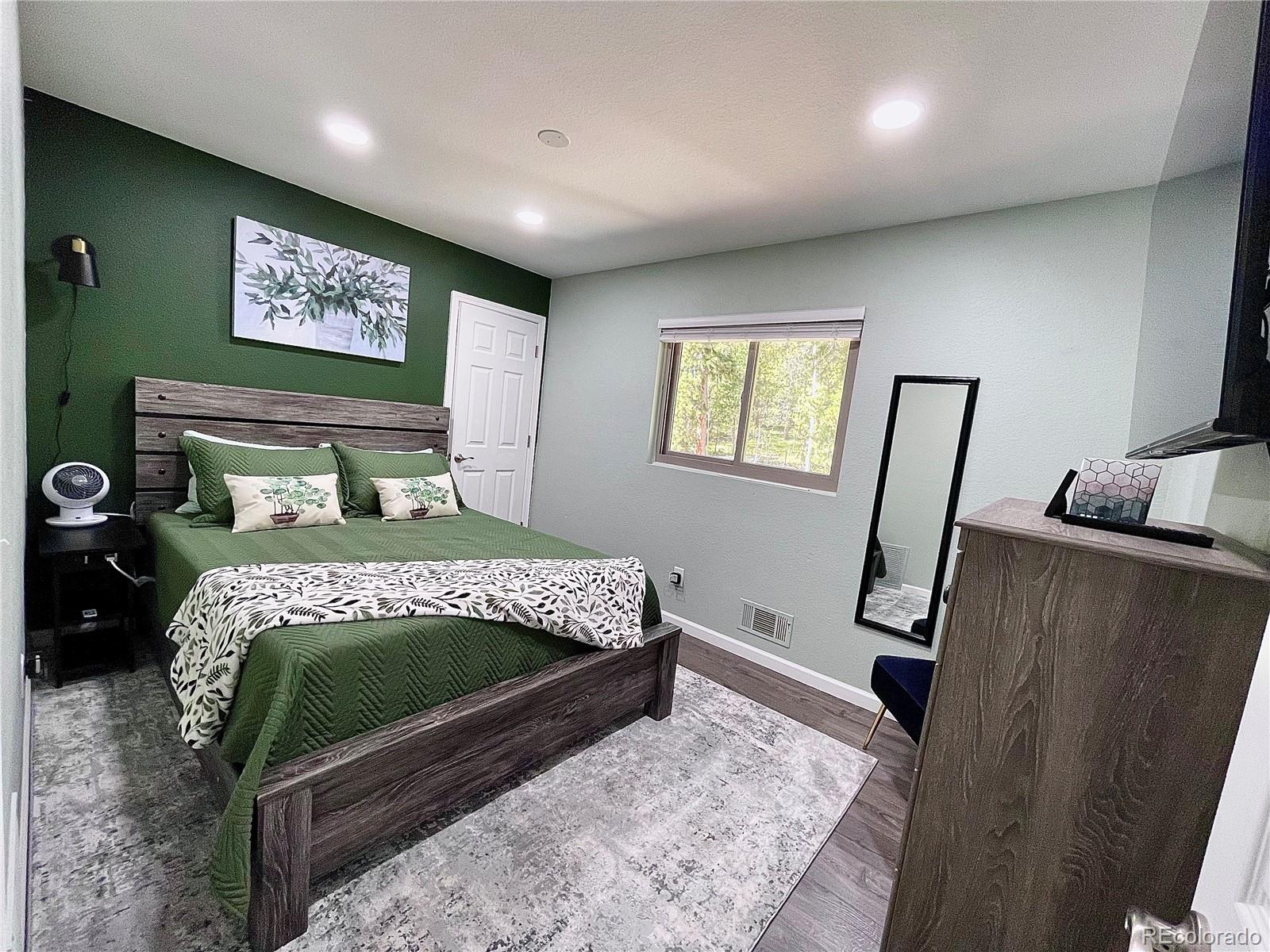 265 Caesar Road Black Hawk, CO 80422 - Photo 33 of 42 a bedroom with a bed a mirror on the dresser and a rug
