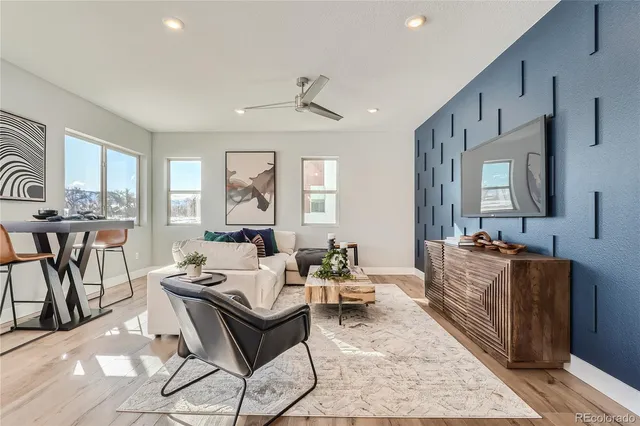 a living room with furniture a flat screen tv and a table