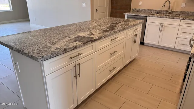 a bathroom with a granite countertop sink and cabinets