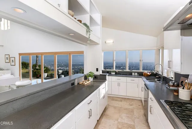 a large kitchen with a large window and stainless steel appliances