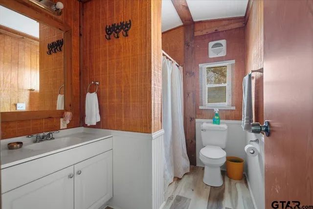 a bedroom with a bed a dresser and next to a window