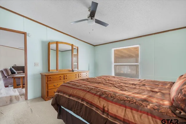 a bedroom with a large bed and a chandelier