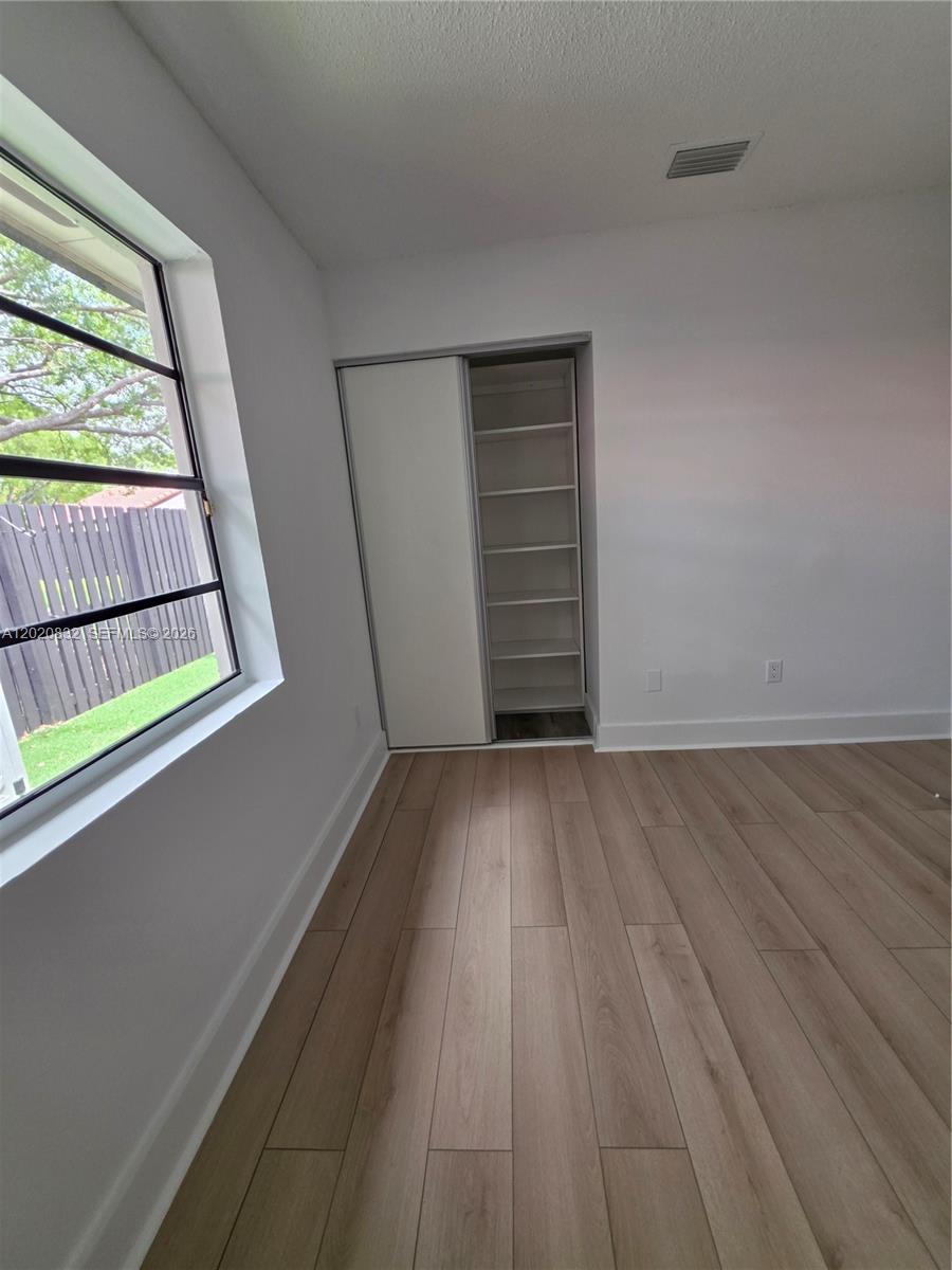 15240 Southwest 45th Terrace, Unit 54F Miami, FL 33185 - Photo 28 of 48 a view of empty room with wooden floor and fan