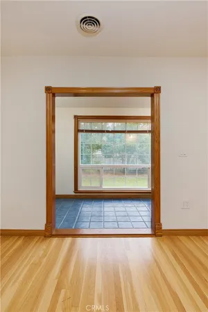 a view of empty room with wooden floor and ceiling fan