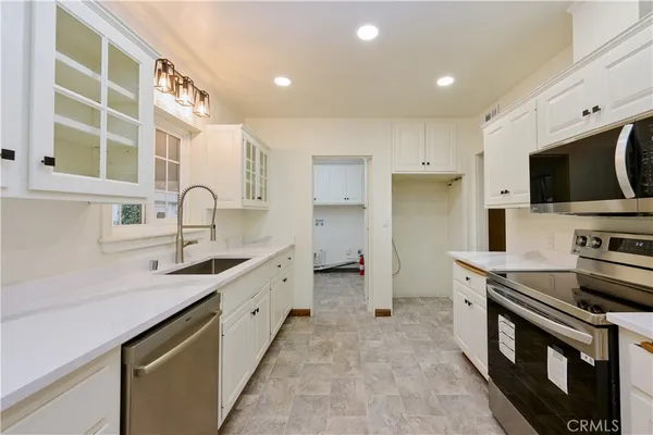 a kitchen with stainless steel appliances granite countertop a sink and a stove