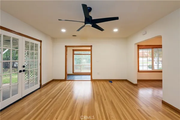 a view of empty room with wooden floor and fan