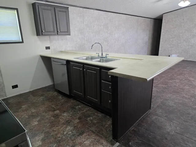 a kitchen with a sink a stove and cabinets