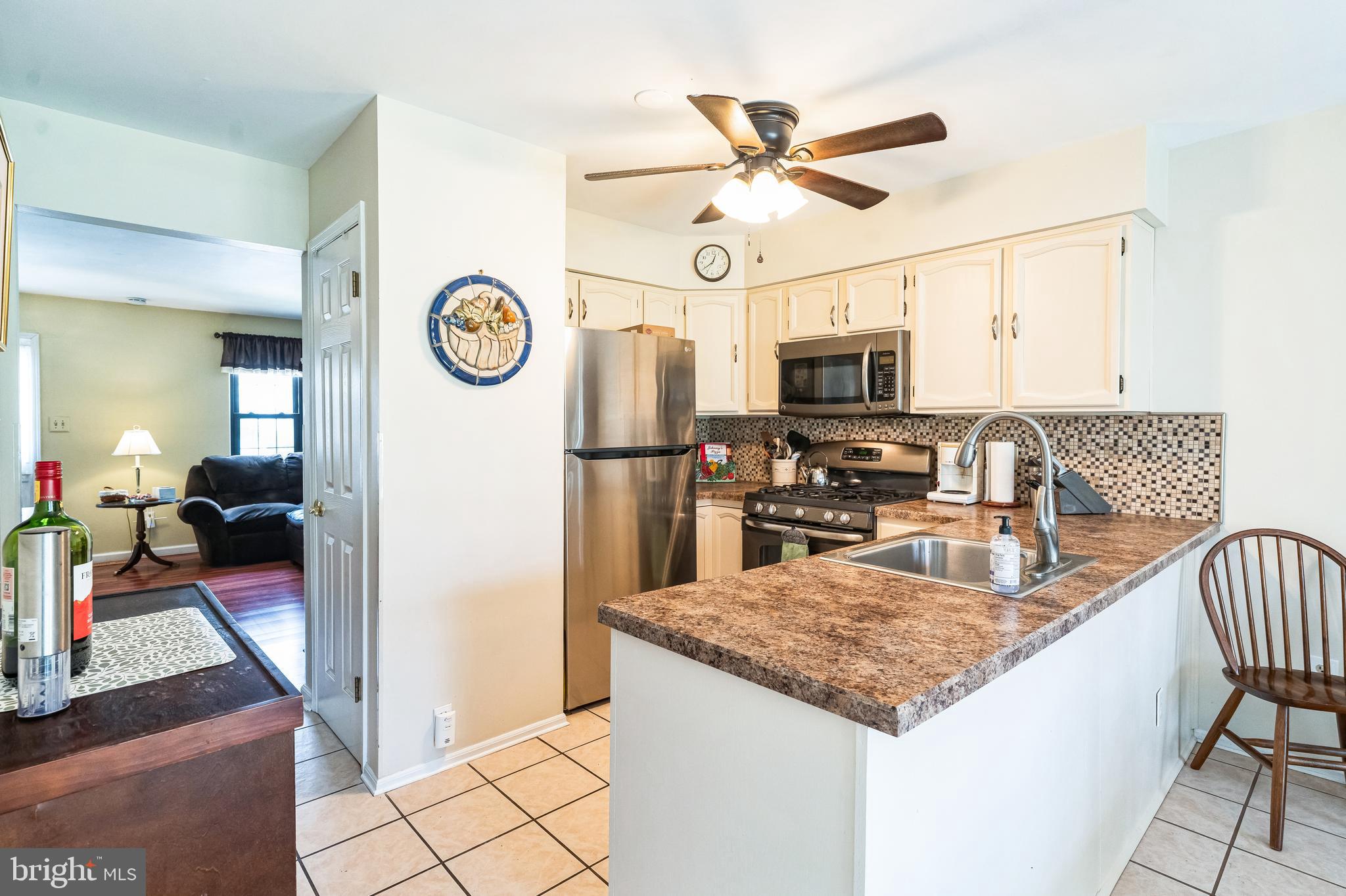 806 Kings Croft Drive Cherry Hill, NJ 08034 - Photo 8 of 31 a kitchen with stainless steel appliances granite countertop a stove top oven a sink a dining table and chairs