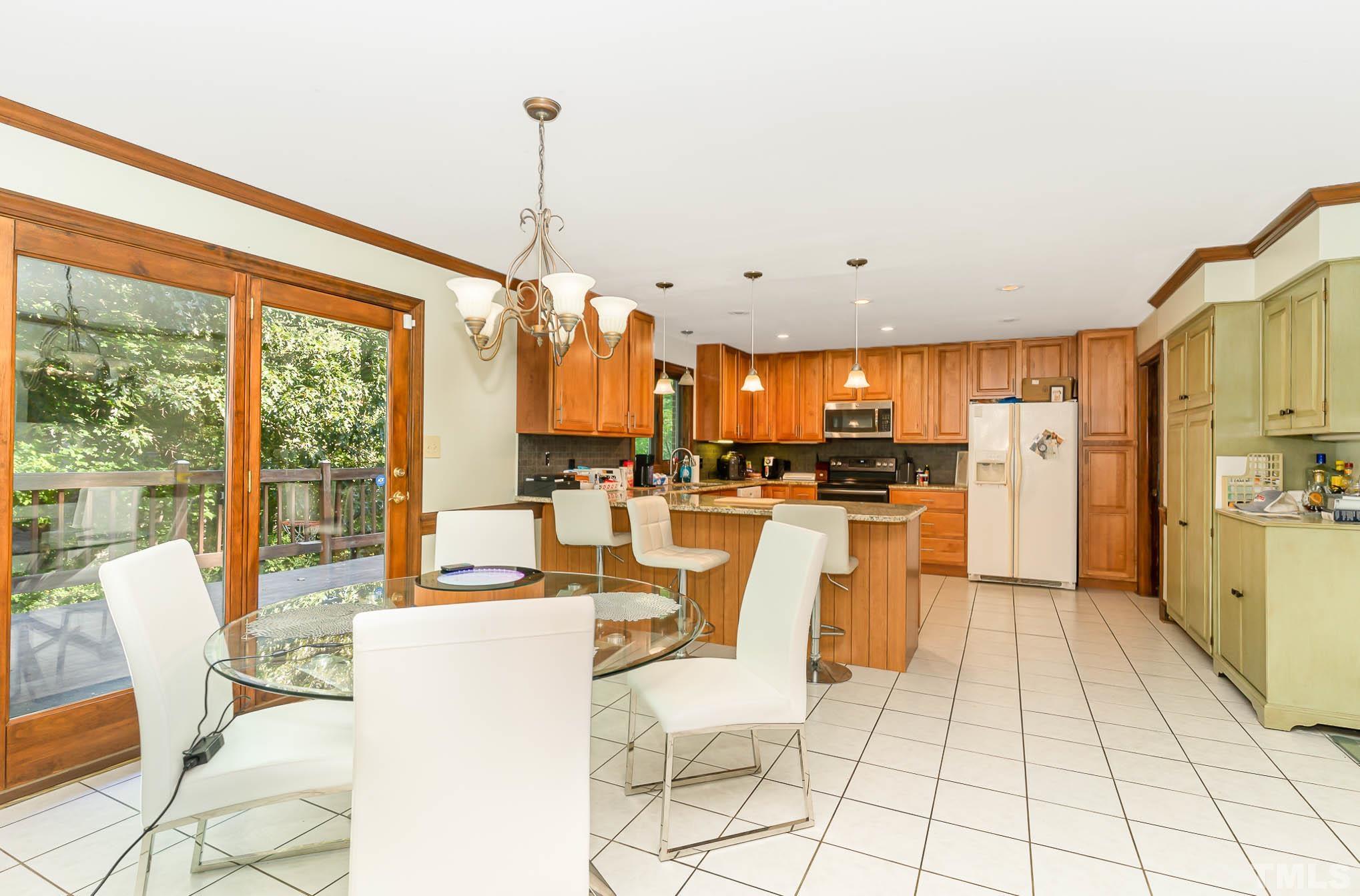 8700 Stage Ford Road Raleigh, NC 27615 - Photo 12 of 25 a dining hall with stainless steel appliances a dining table chairs and view of living room