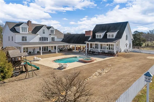 a view of a big house with wooden fence