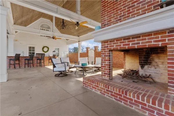 a kitchen with stainless steel appliances granite countertop a stove top oven a sink a dining table and chairs with wooden floor