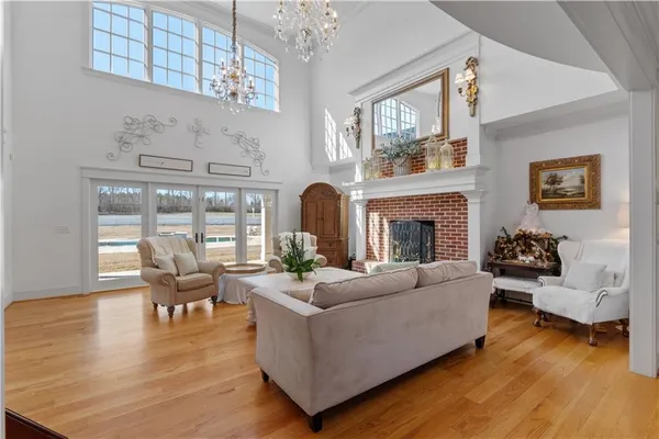 a living room with furniture a large window and a chandelier