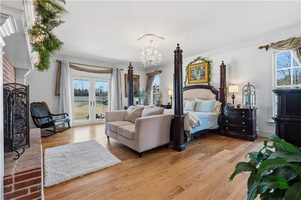 a kitchen with stainless steel appliances granite countertop a refrigerator a sink dishwasher a dining table and chairs with wooden floor