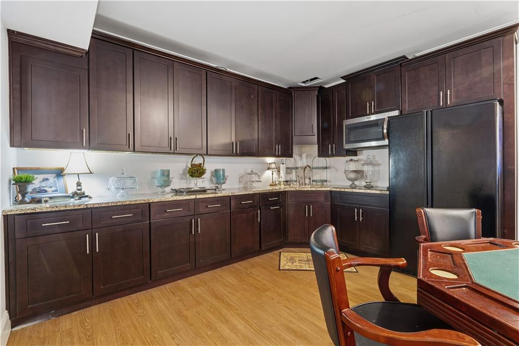 31 Duck Pond Road Roopville, GA 30170 - Photo 97 of 136 a kitchen with stainless steel appliances granite countertop a refrigerator a sink dishwasher a dining table and chairs with wooden floor