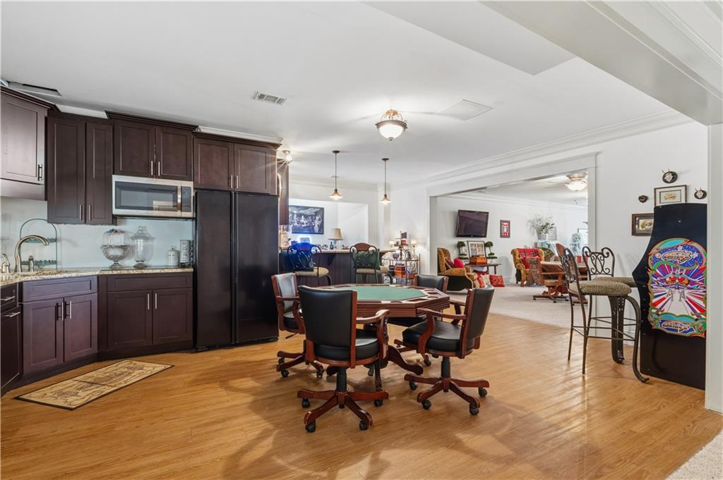 31 Duck Pond Road Roopville, GA 30170 - Photo 98 of 136 a kitchen with stainless steel appliances kitchen island granite countertop a dining table chairs refrigerator and cabinets