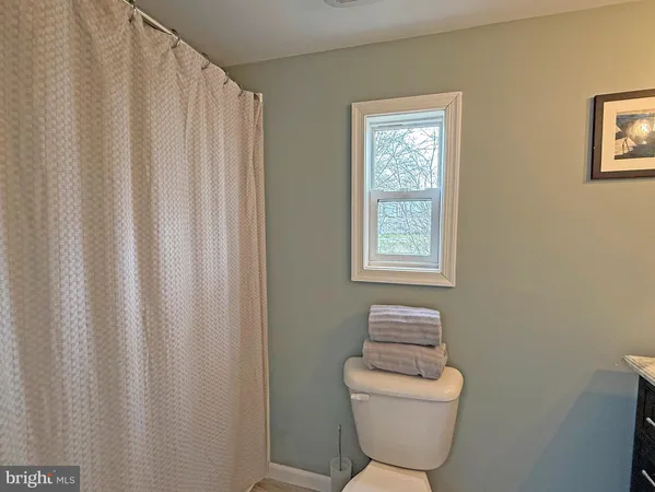 a bathroom with a toilet and a window