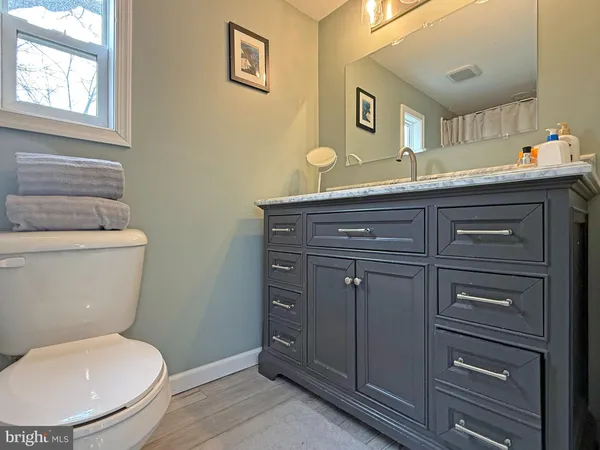 a bathroom with a toilet a sink and mirror