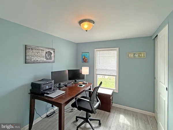 a view of a workspace with furniture and a window