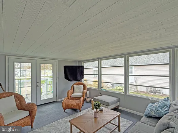 a living room with furniture a flat screen tv and a large window