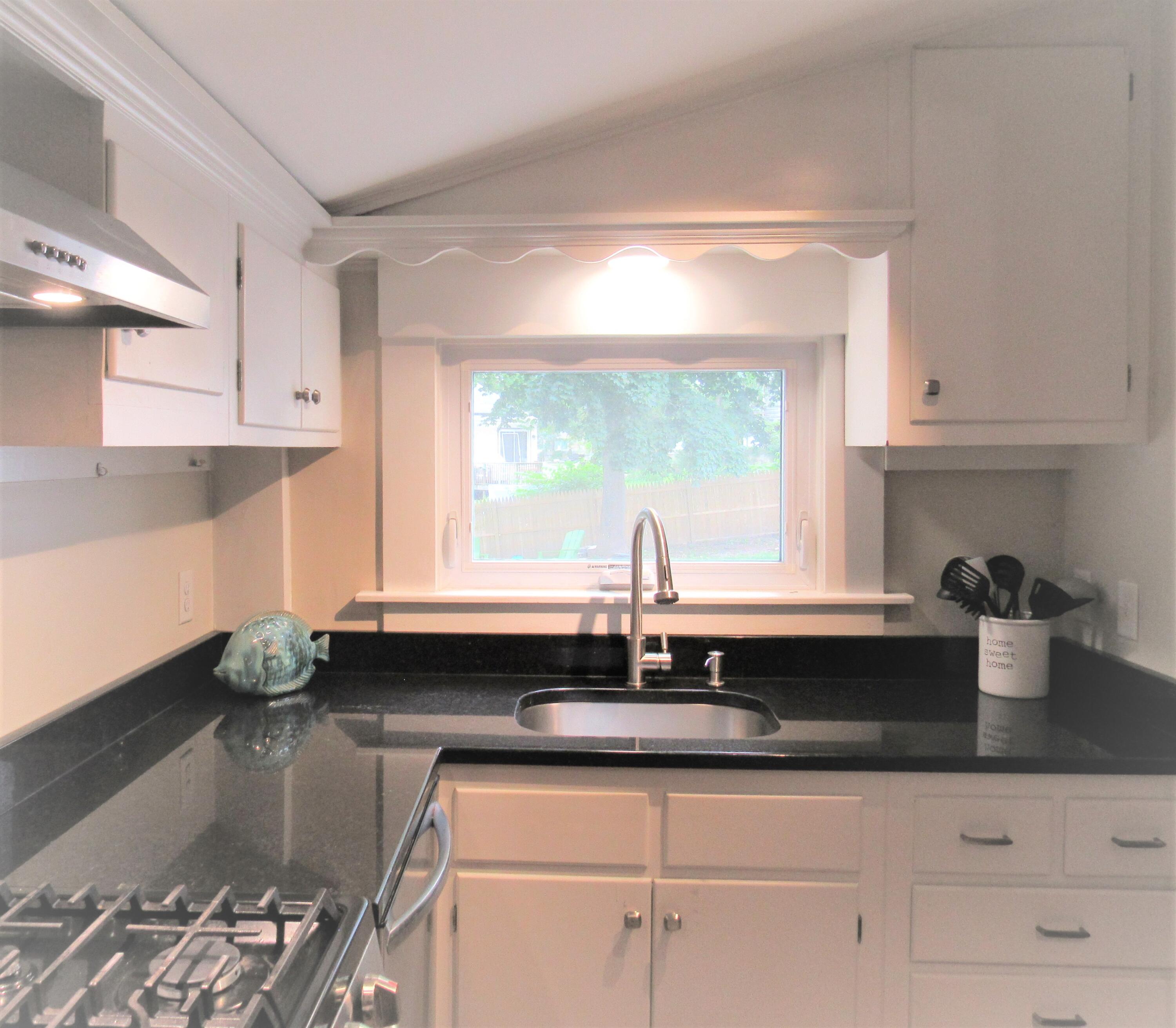 103 Baxter Road Hyannis, MA 02601 - Photo 11 of 31 a kitchen with a sink cabinets and window