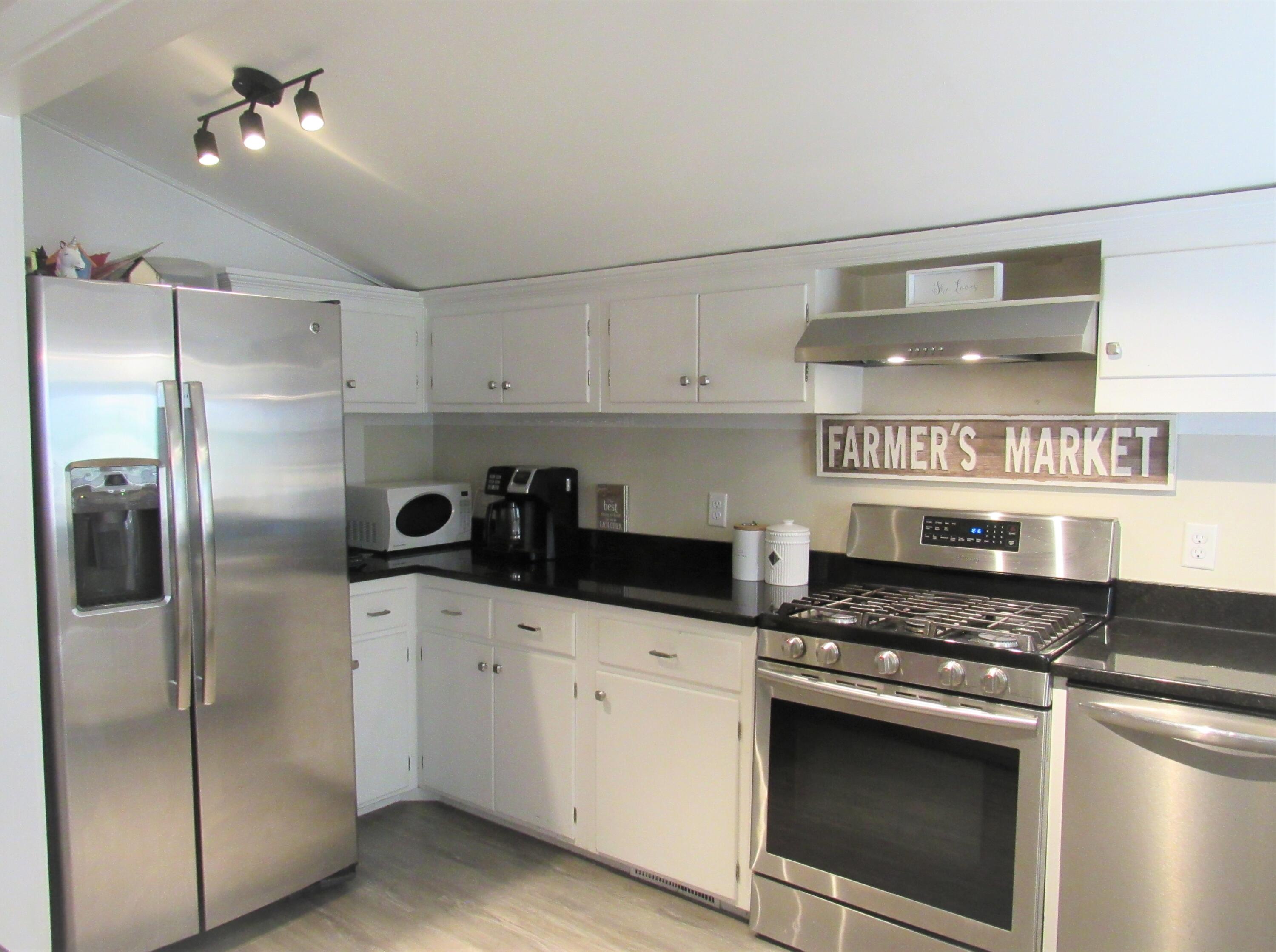 103 Baxter Road Hyannis, MA 02601 - Photo 9 of 31 a kitchen with stainless steel appliances granite countertop a stove a refrigerator and a sink with wooden floor