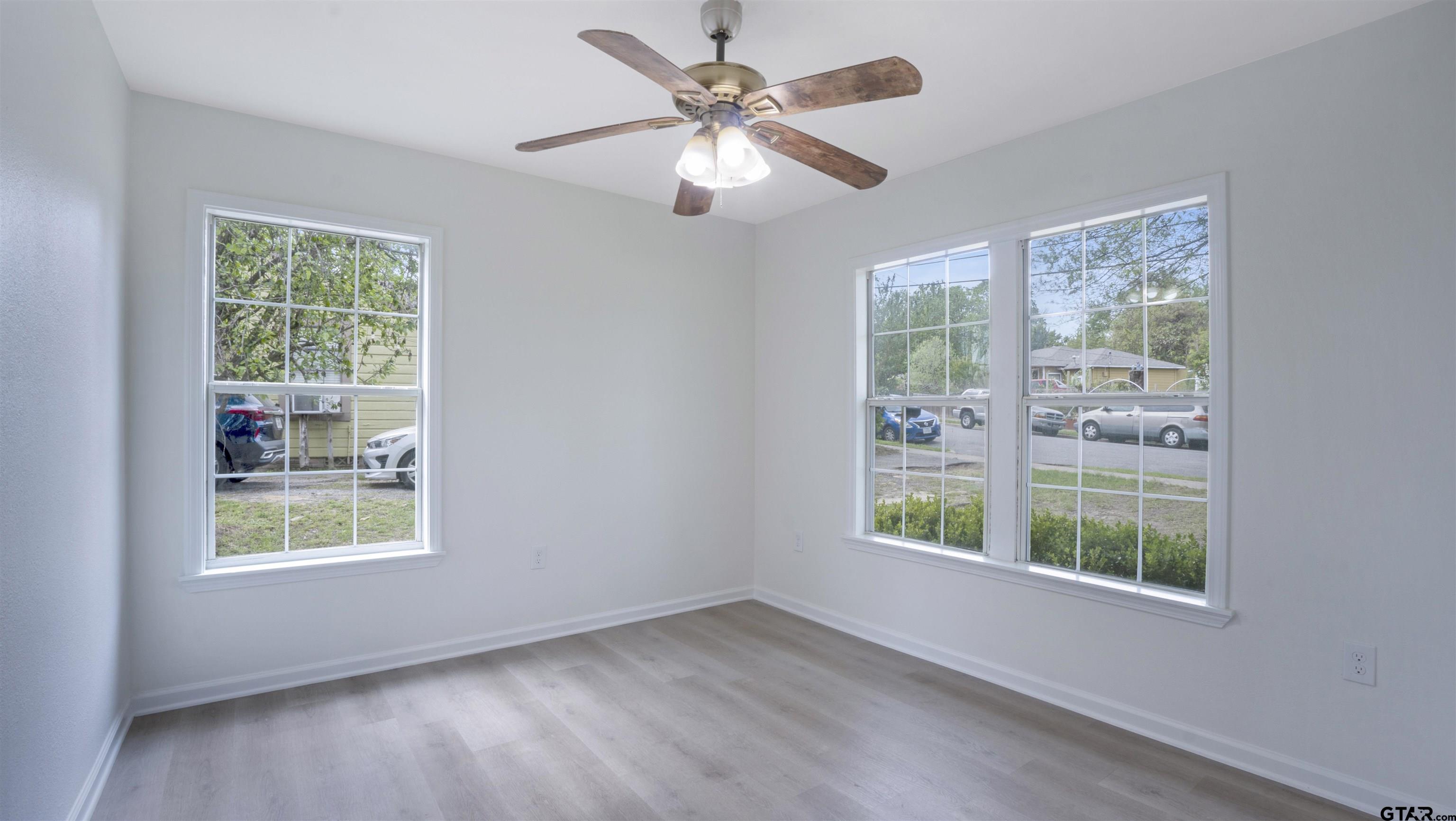 1925 Cushing Drive Tyler, TX 75702 - Photo 17 of 30 a view of an empty room with windows and chandelier fan