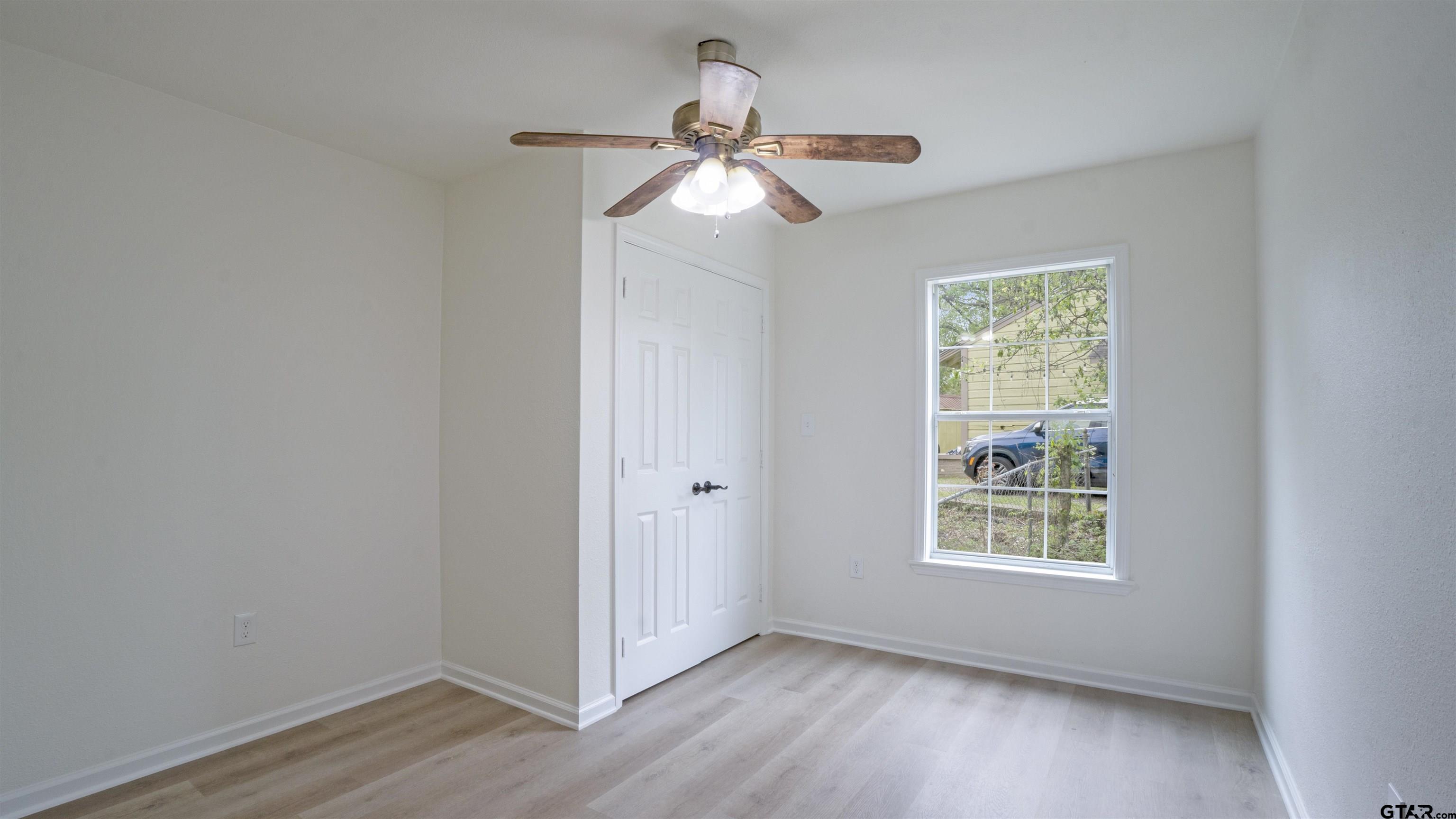 1925 Cushing Drive Tyler, TX 75702 - Photo 19 of 30 a view of an empty room with wooden floor and a window