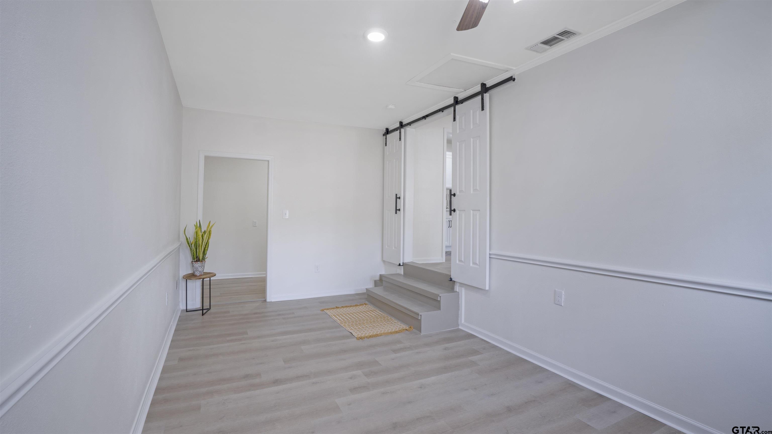 1925 Cushing Drive Tyler, TX 75702 - Photo 21 of 30 a view of an empty room with wooden floor and a window