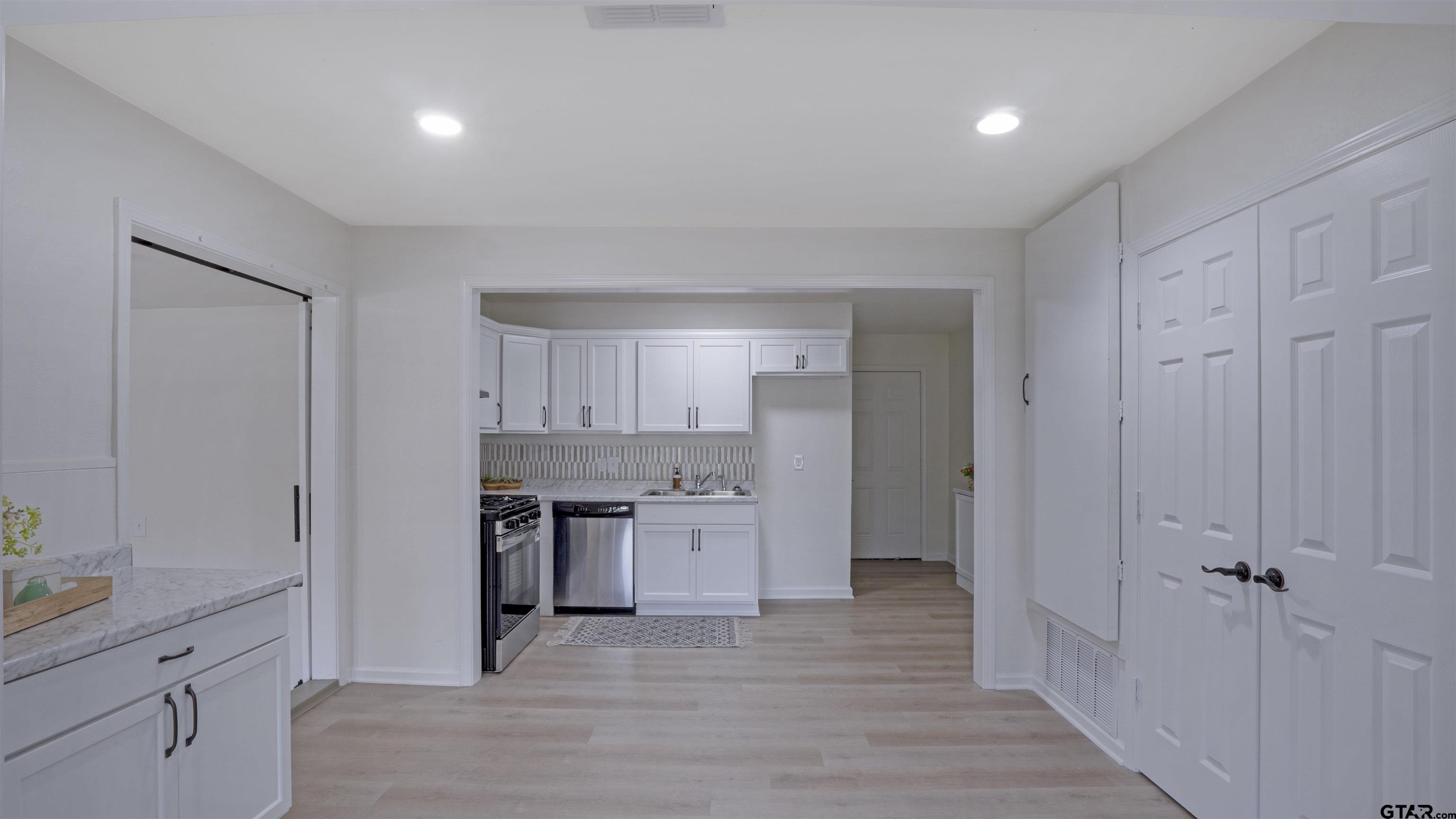 1925 Cushing Drive Tyler, TX 75702 - Photo 7 of 30 a view of a kitchen with a sink and dishwasher a refrigerator with wooden floor