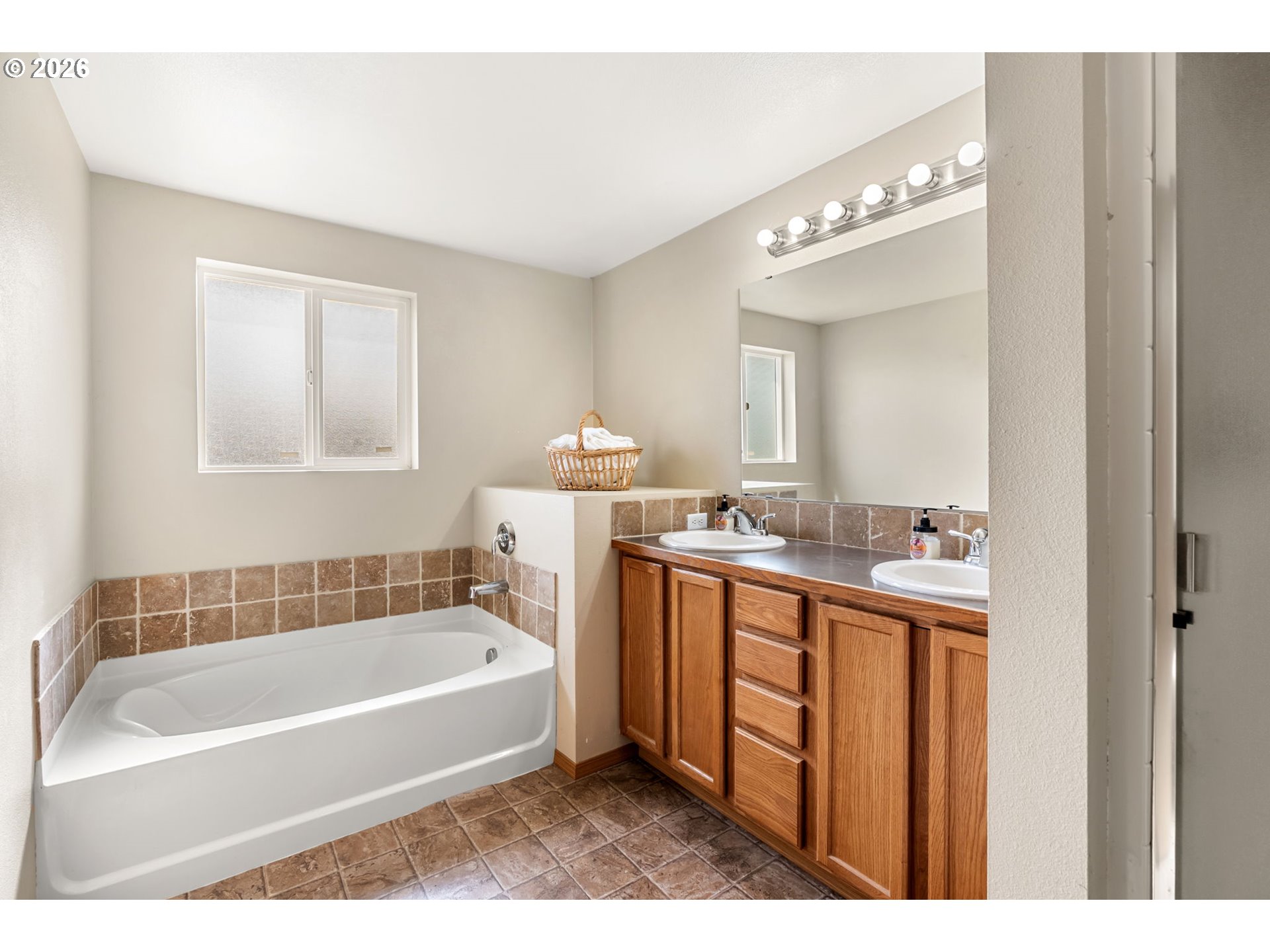 100 Grace Way Goldendale, WA 98620 - Photo 13 of 48 a bathroom with a bathtub a mirror a double vanity sinks and vanity