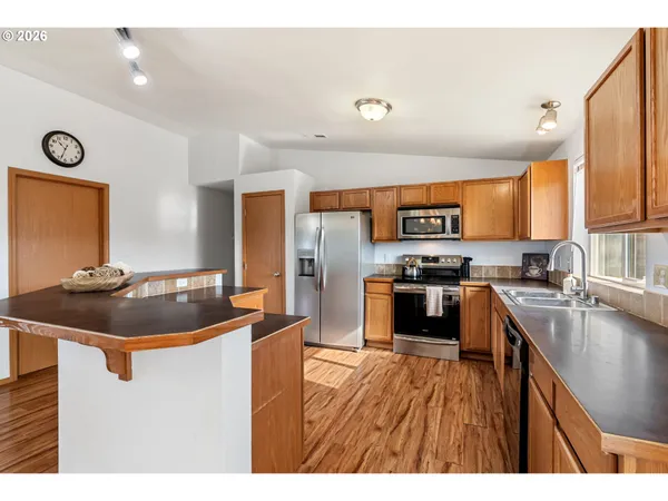 a kitchen with stainless steel appliances granite countertop a sink stove and refrigerator