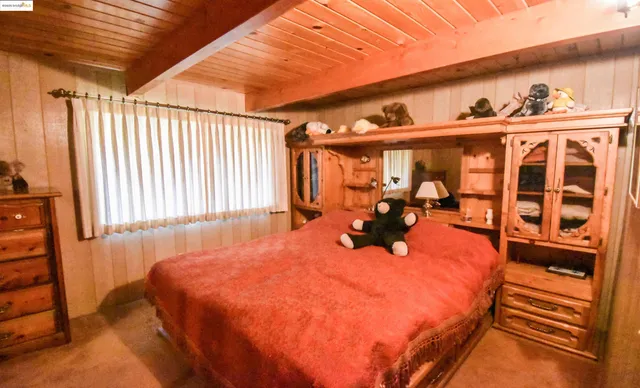 a bed sitting in a bedroom next to a window